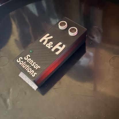The K&H salt sensor — a compact branded enclosure with two ultrasonic transducers